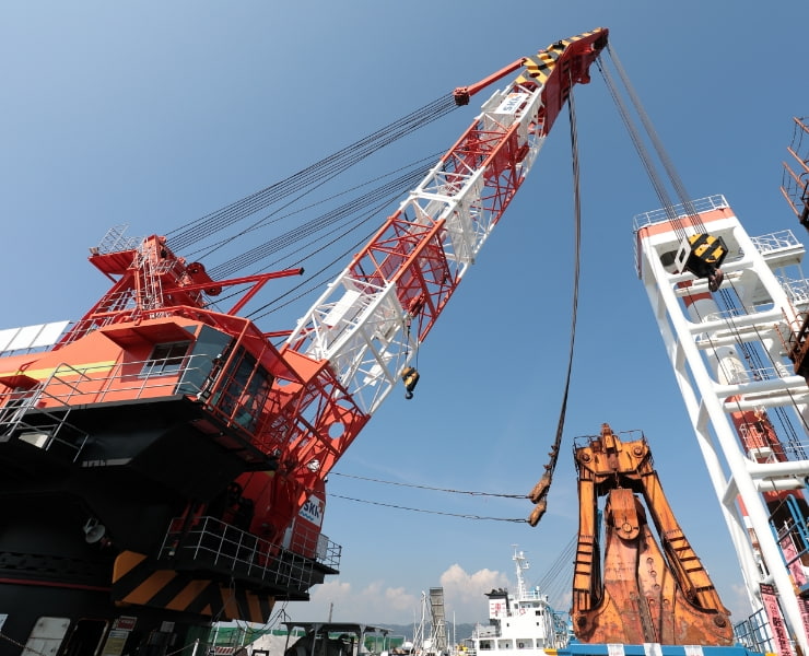 大型船舶の荷役作業を行う赤と白の港湾クレーン。