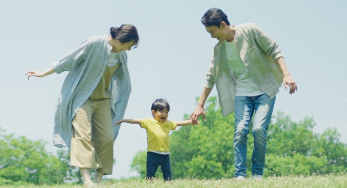 子供と公園で遊ぶ幸せな家族の風景。