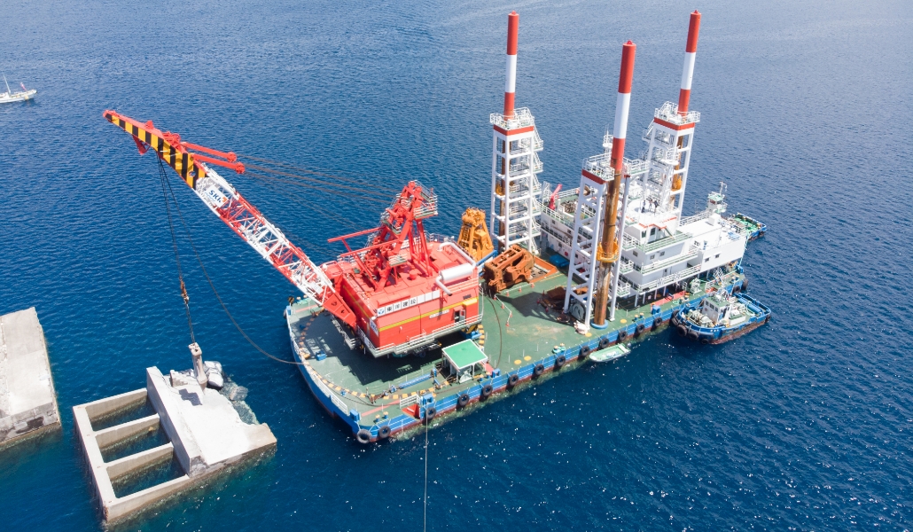 海上クレーン船が港湾建設用コンクリート構造物を設置している様子。