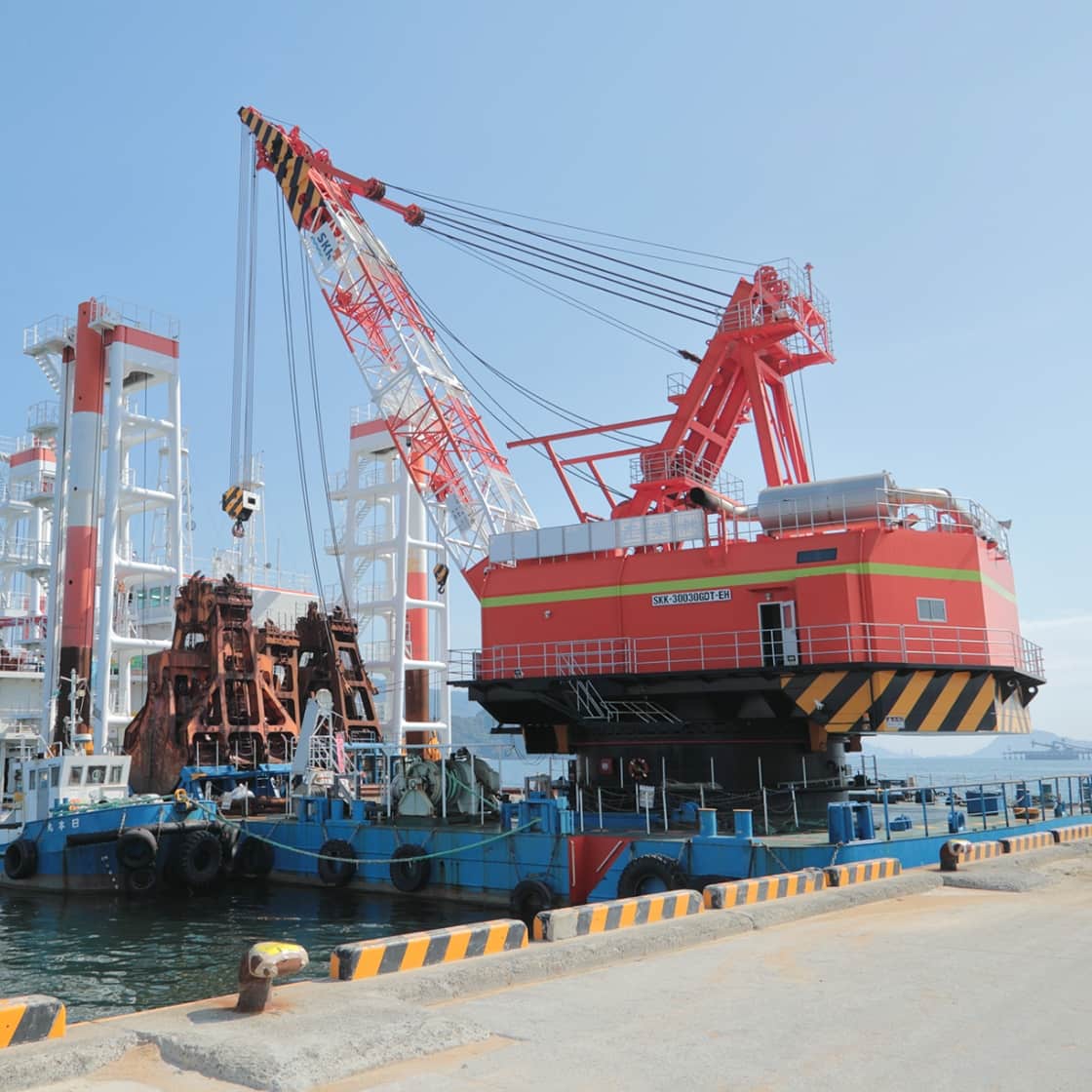 港の大型クレーン船と青空の写真