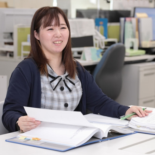 オフィスで書類を手に笑顔の女性社員