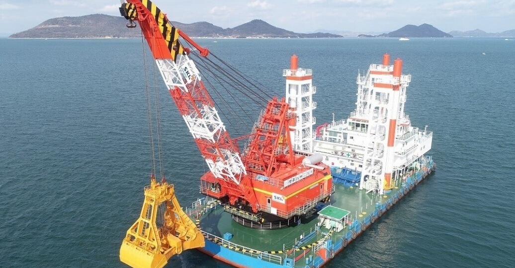海洋作業用の大型クレーン船とグラブバケットの風景。