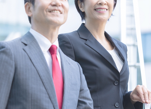 ビジネスマンとビジネスウーマンが微笑んでいるオフィスの写真