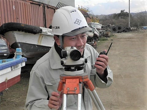 ヘルメットをかぶった男性がカメラを持っている様子です。